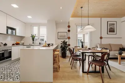 a kitchen with white cabinets and a large island with stools at Arenal - 3 bedrooms and terrace in Sarrià in Barcelona