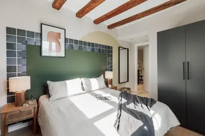 a bedroom with a bed with a table with a lamp at Izmit - 2 bedrooms and balcony in Sant Pere in Barcelona