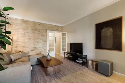 a living room with a couch and a brick wall at Morell - 3 bedroom and office in Eixample Esquerra in Barcelona