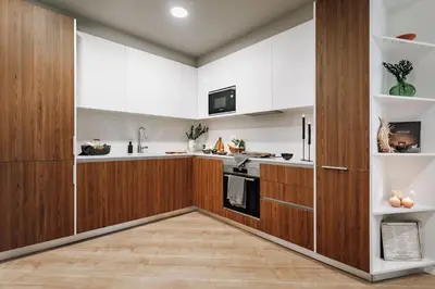 a kitchen with white cabinets and wood paneling at Algar - 1 bedroom and balcony in Eixample Esquerra in Barcelona
