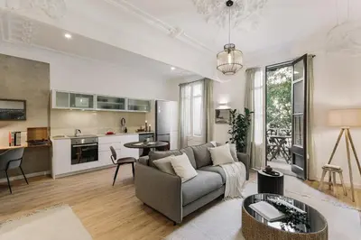 a living room with a large mirror on the wall at Baia - Studio and balcony in Eixample Esquerra in Barcelona