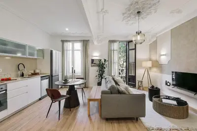 a living room with a couch and a table at Baia - Studio and balcony in Eixample Esquerra in Barcelona