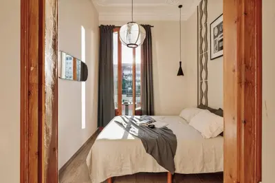 a bedroom with a bed and a door to a hallway at Kusku - 3 bedrooms and balcony in Eixample Dreta in Barcelona