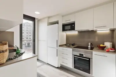 a dining room with a table and chairs and a kitchen at Aliga - 3 bedroom and pool in Les Corts in Barcelona