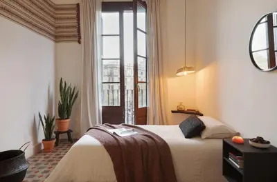 a bedroom with two beds and a large window at Taoudeni - 3 bedrooms in Eixample Esquerra in Barcelona
