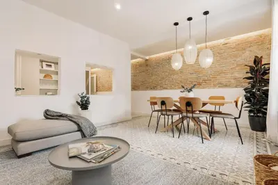a dining room table with chairs and a brick wall at Tikal - 3 bedrooms and balcony in Sant Gervasi in Barcelona