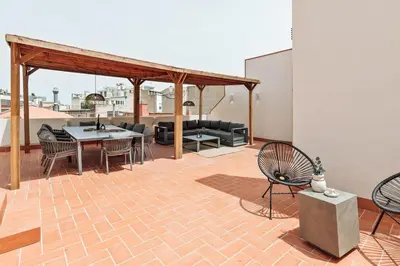 two chairs sitting next to a table with a vase at Baronissi - 2 bedrooms and terrace in Ciutat Vella in Barcelona