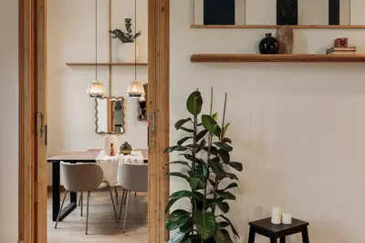 a hallway with a door and a plant on a stool at Ada - 2 bedrooms and balcony in Eixample Dreta in Barcelona