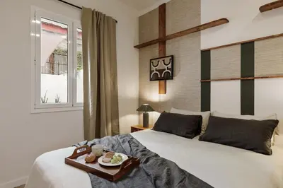 a kitchen with white cabinets and a wooden counter top at Kayra - 2 bedrooms and terrace in La Sagrada Familia in Barcelona
