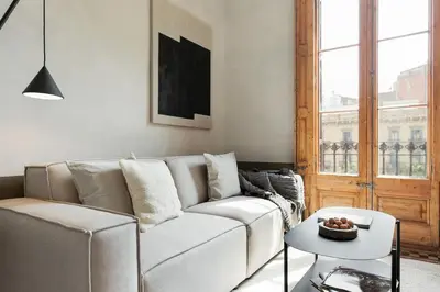 a living room with a white couch and a table at Serre - Studio in Eixample Dreta in Barcelona