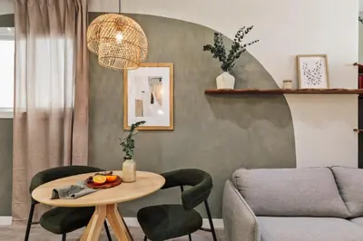 a bed with a tray with two cups and a book at Freso - Studio in Eixample Esquerra in Barcelona
