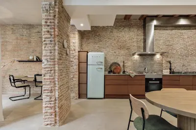 a bedroom with a king sized bed and a table at Galata - 3 bedrooms and terrace in Vila de Gràcia in Barcelona