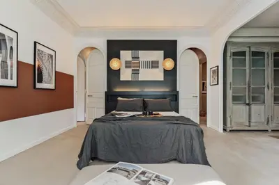 a bedroom with a bed and a table and windows at Galata - 3 bedrooms and terrace in Vila de Gràcia in Barcelona