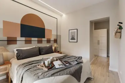 a small bedroom with a bed and a lamp at Davut - 3 bedrooms and office in Eixample Esquerra in Barcelona