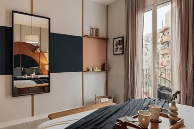 a small bedroom with a bed with a mirror at Yesil - 2 bedrooms and office in Sant Antoni in Barcelona
