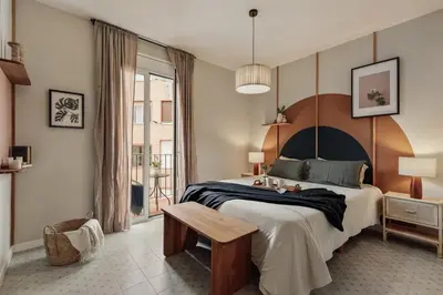 a bed with a large wooden headboard with two lamps at Yesil - 2 bedrooms and office in Sant Antoni in Barcelona