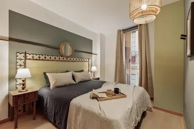 a bedroom with a bed with a tray with books and a mirror at Mercan - 2 bedrooms in Sant Pere in Barcelona