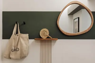 a living room with a green wall with a television at Caliph - 2 bedrooms and office in El Putxet i el Farró in Barcelona