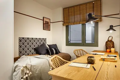 a room with a bed and a desk and a table at Kufra - 3 bedrooms in Eixample Esquerra in Barcelona