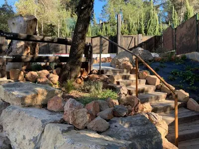 a stone staircase with a tree and rocks at LAMAGADA - Casa en Montseny con Piscina Salada in Seva