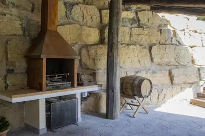 a stone wall with an oven and a barrel at LAMAGADA - Casa en Montseny con Piscina Salada in Seva