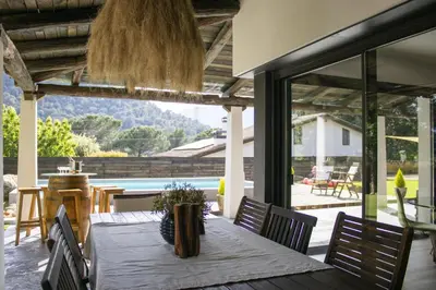 a dining room with a table and chairs and a large window at LAMAGADA - Casa en Montseny con Piscina Salada in Seva