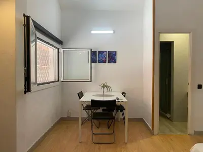 a table and chairs in a room with a window at Gracia&Güell Home in Barcelona