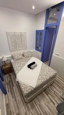 a bedroom with two beds and a blue door at Cosy apartment next to the sea in Barcelona