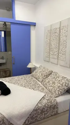 a bedroom with two beds and a blue door at Cosy apartment next to the sea in Barcelona