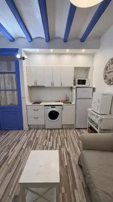 a kitchen with white cabinets and a blue ceiling at Cosy apartment next to the sea in Barcelona