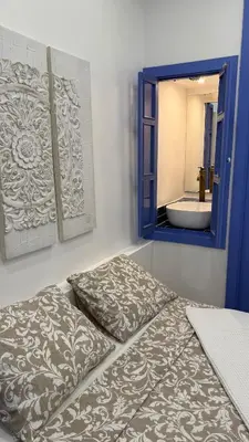 a bed in a room with a mirror and a sink at Cosy apartment next to the sea in Barcelona