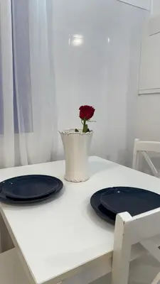 a table with two plates and a flower in a vase at Cosy apartment next to the sea in Barcelona
