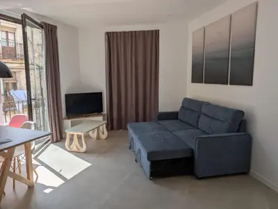 a living room with a blue couch and a table at Ca l'Emília, hasta 6 pers, Monistrol de Montserrat in Monistrol