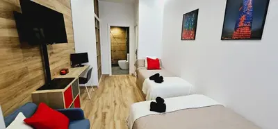 a living room with two beds and a tv at 2 apartamentos juntos ideal grupos cerca Barcelona in Badalona