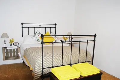 a bedroom with a bed with yellow pillows on it at Casa rural Cal Farriol in Mediona