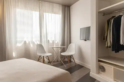 a hotel room with a bed and two chairs and a table at Sixties Ramblas in Barcelona
