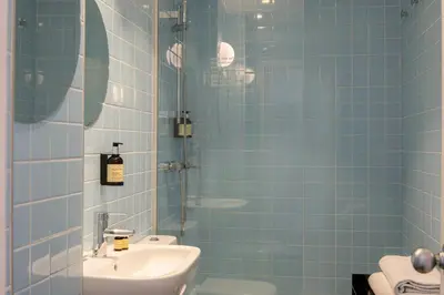 a blue tiled bathroom with a sink and a shower at Sixties Ramblas in Barcelona