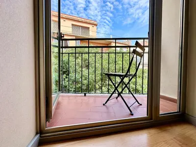 a chair sitting on a balcony with a window at Hotel Turin Barcelona in Barcelona