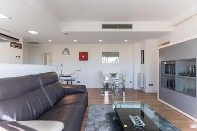 a living room with a leather couch and a table at Glorious Sunny penthouse near the beach in Barcelona