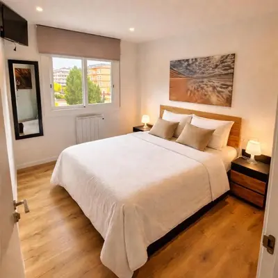 a bedroom with a large white bed and a window at Habitación premium in Vilanova i la Geltrú