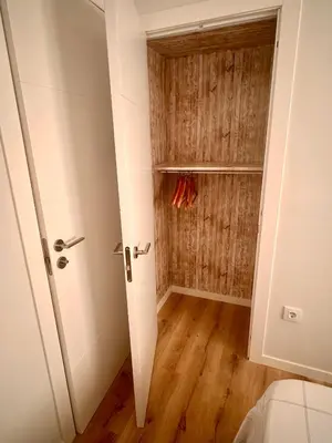 a room with a door and a closet with wooden floors at Habitación premium in Vilanova i la Geltrú