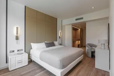 a bedroom with a large white bed and a chair at Sweett - Paseo de Gracia - City Centre in Barcelona