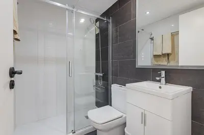 a bathroom with a shower and a toilet and a sink at Quiet modern 2 bed apartment with Balcony, Pool and Free Parking in Barcelona