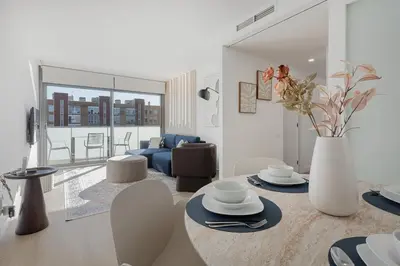 a living room with a table with a vase of flowers at Quiet modern 2 bed apartment with Balcony, Pool and Free Parking in Barcelona