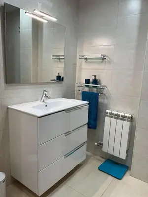 a white bathroom with a sink and a mirror at Holiday near Sitges with private terrace in Vilanova i la Geltrú