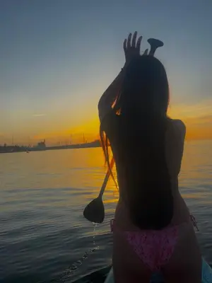 a woman standing in the water watching the sunset at Barcelona's Gem in Barcelona