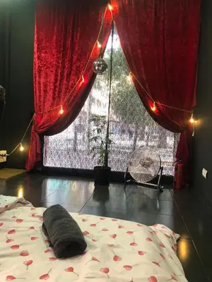 a bedroom with a bed and a window with red curtains at Piso para pareja in Barcelona