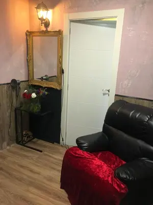 a living room with a black leather couch and a mirror at Piso para pareja in Barcelona