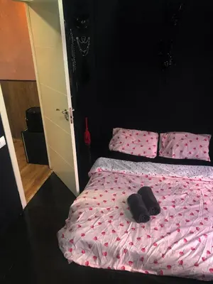 a bed with pink sheets and a pair of shoes on it at Piso para pareja in Barcelona