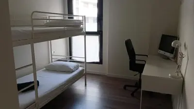 a room with bunk beds and a desk and a computer at Contemporary 2BR with Pool & Gym in Hospitalet de Llobregat